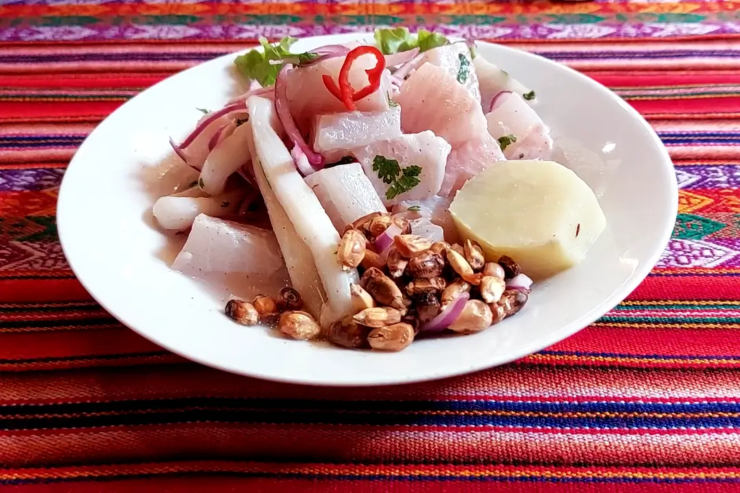 Ceviche peruano servido no restaurante Doña Bertha, com peixe marinado, cebola roxa, cancha e batata-doce.