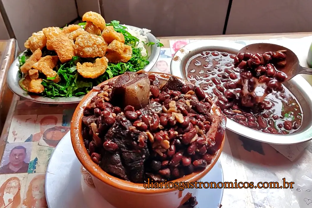 Feijoada completa do Bar do Adalto com arroz, couve, torresmo, farofa e carnes variadas.