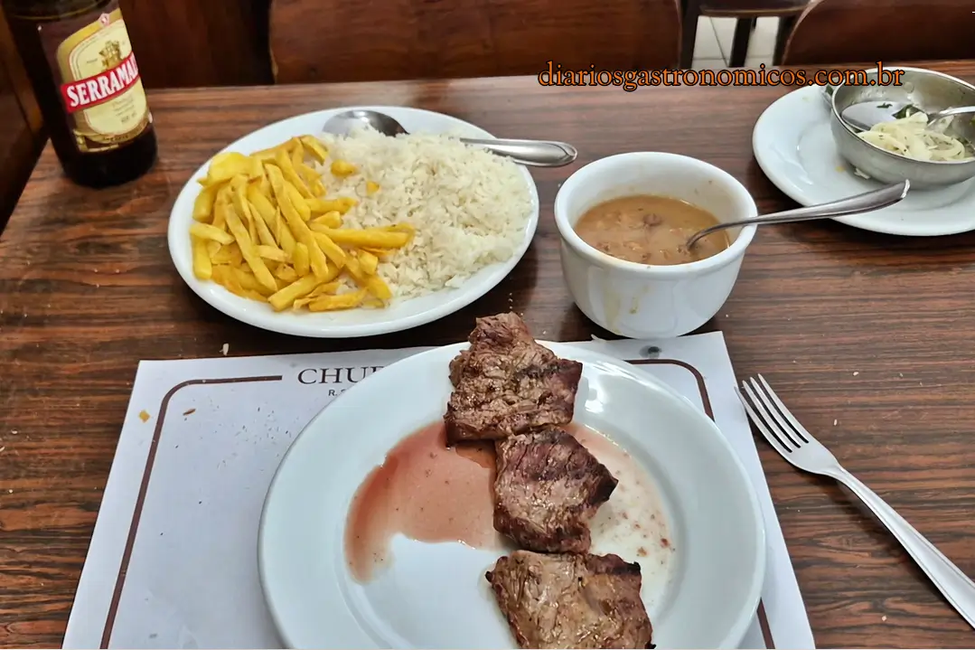 Prato de alcatra grelhada com arroz, batatas fritas e feijão gordo servido no restaurante Churrasqueto em São Paulo.