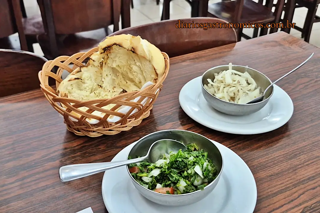 Pão tostado na brasa servido com vinagrete e cebola no couvert do restaurante Churrasqueto.