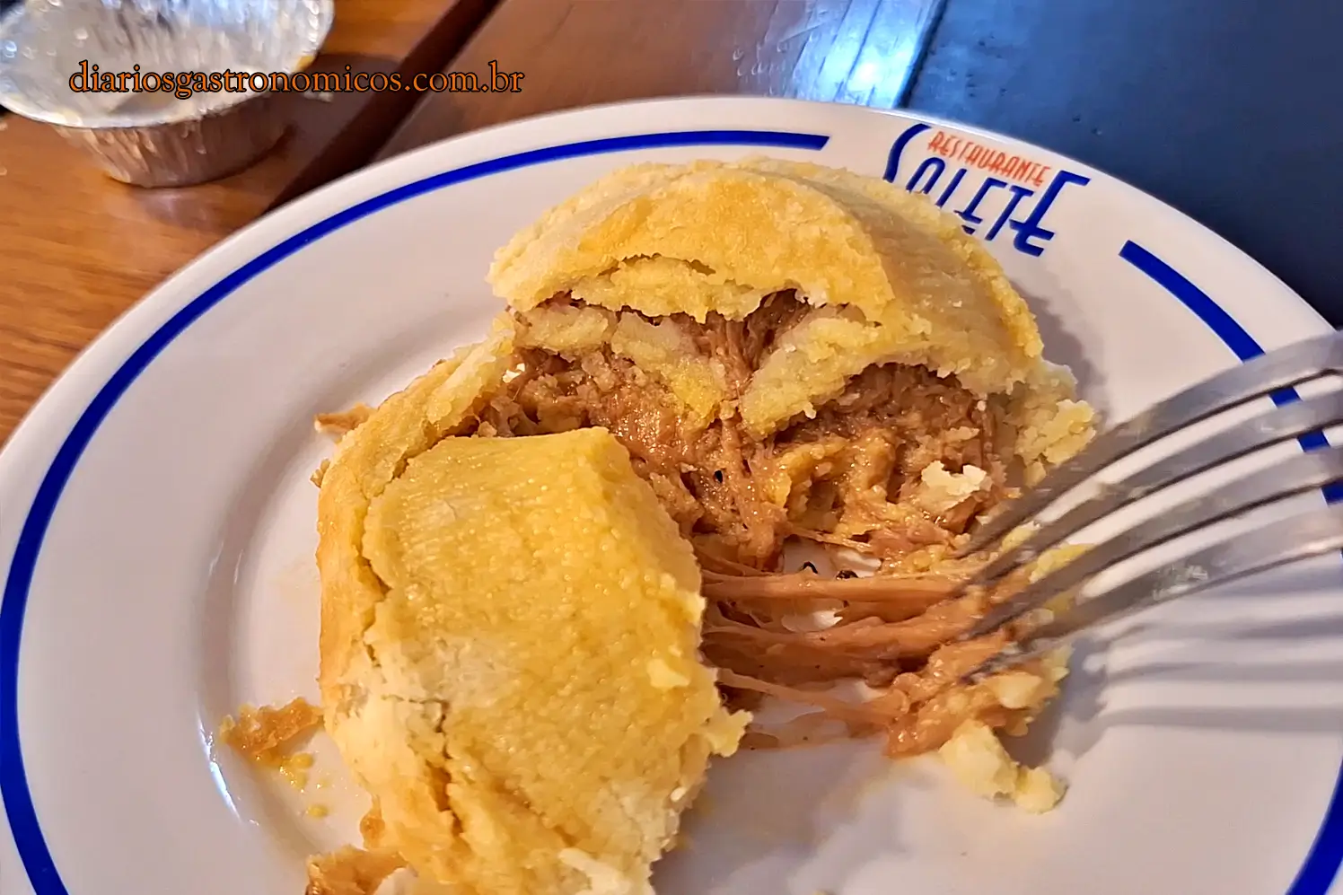 Empada de costela com agrião aberta ao meio, revelando recheio de costela desfiada no Restaurante Salete.