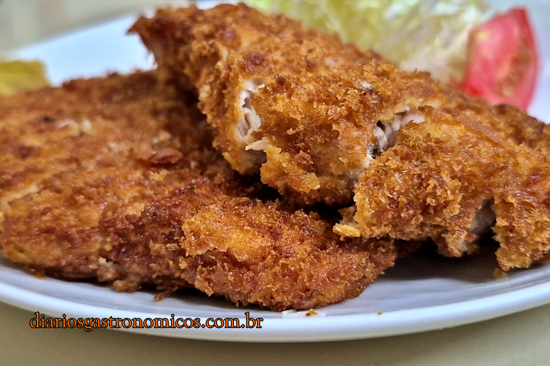 Close do tonkatsu do Ajissai mostrando a crosta dourada e crocante da farinha panko sobre o lombo suíno empanado.