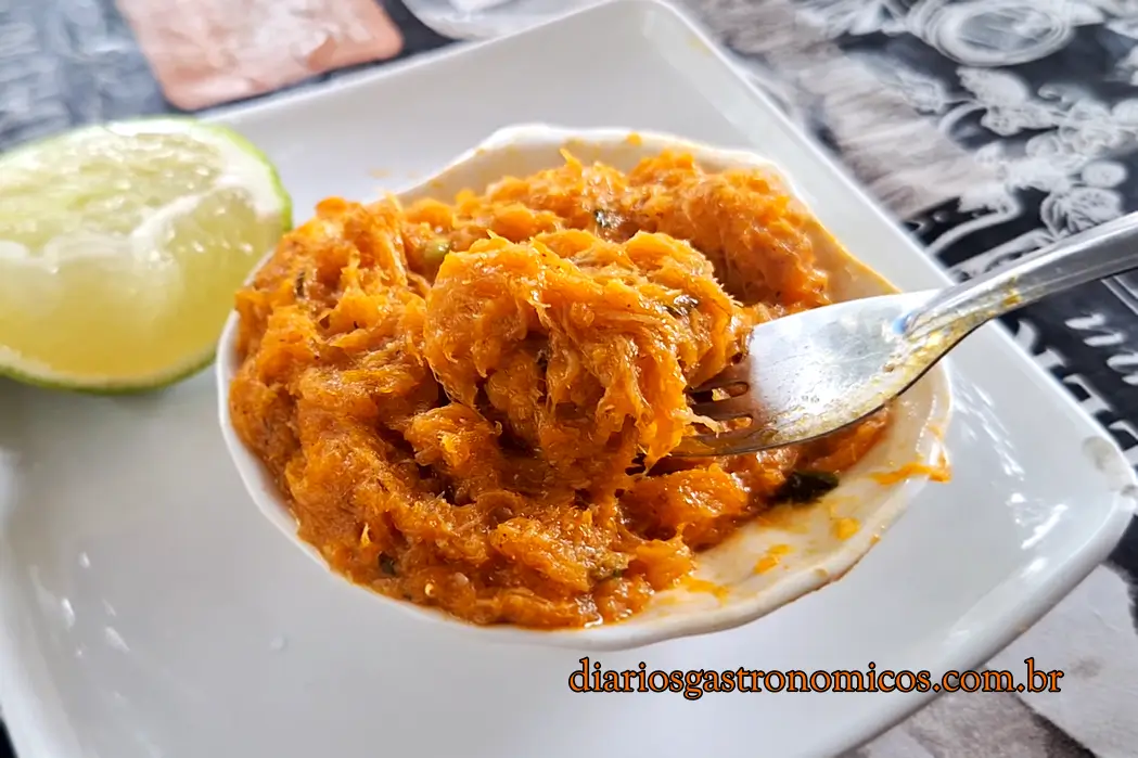 Casquinha de siri com carne desfiada e temperos, servida em prato branco com limão no Boteko do Peixe, no Rio de Janeiro.